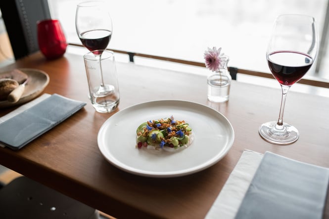A plate of food and wine on a counter.