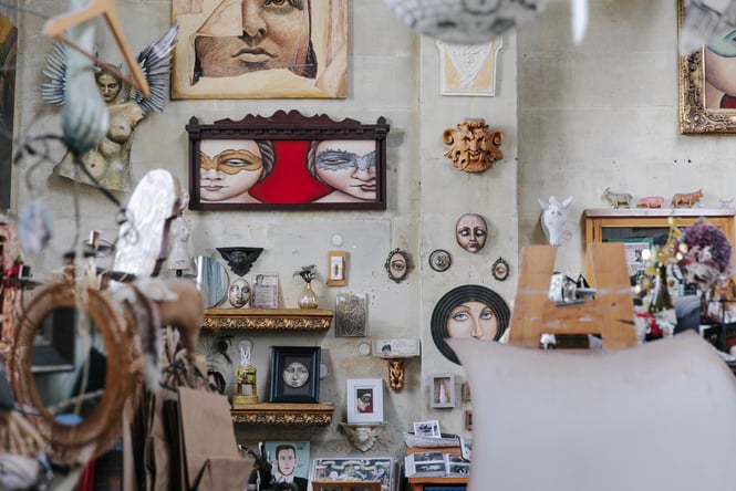 Art and trinkets on display on walls inside Grainstore Gallery.