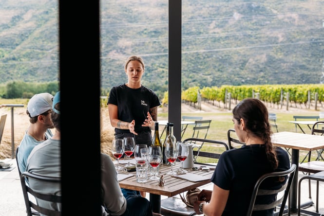 A staff member chatting to a table of customers at a resturant.