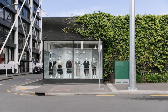Mannequins in window in a store covered with green foliage in Britomart.