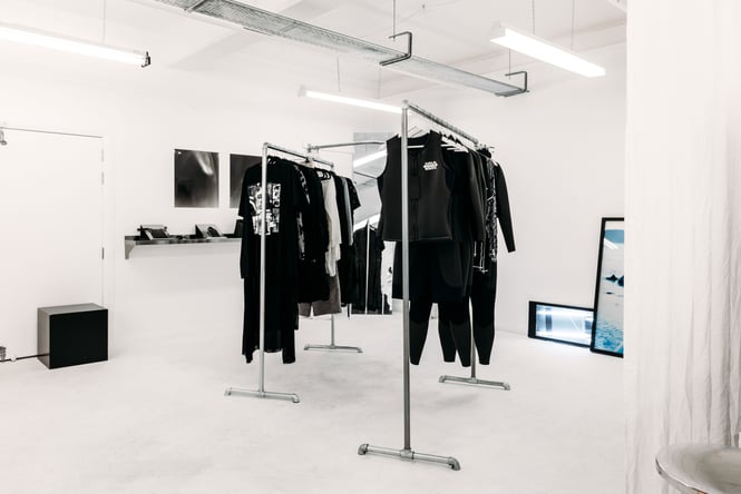 Black clothes on display inside a white room.