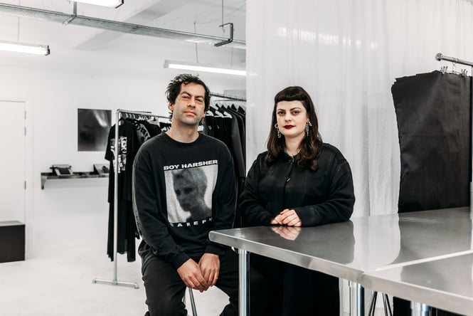 A man and woman wearing black looking at camera.