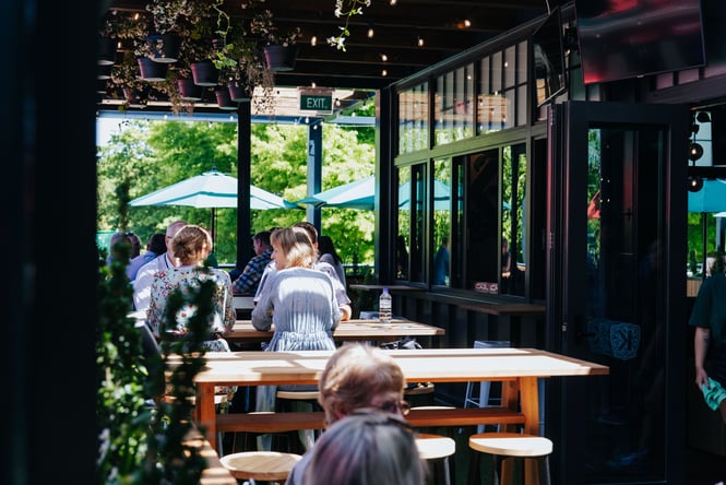 People dining outside a restaurant on a sunny day.