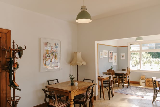 Wooden tables and chairs in a sunny room.