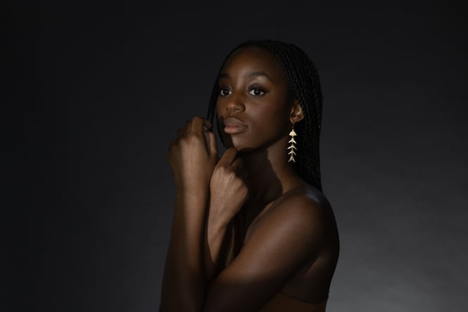 A woman with her arms crossed looking into the distance.