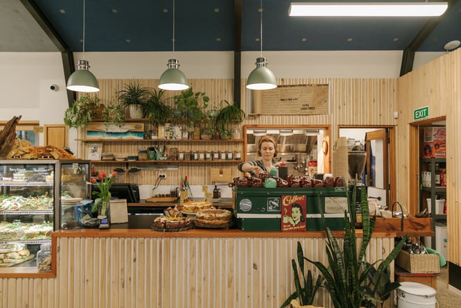 Woman barista standing behind counter at Dune Cafe in New Brighton