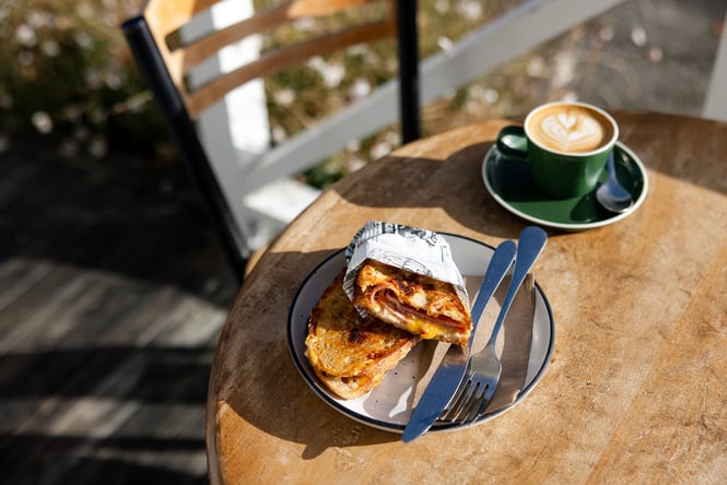 Close up of cheese toastie and coffee on outside table at General Post in Tai Tapu