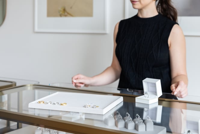 Shop assistant behind the jewellery cabinet.