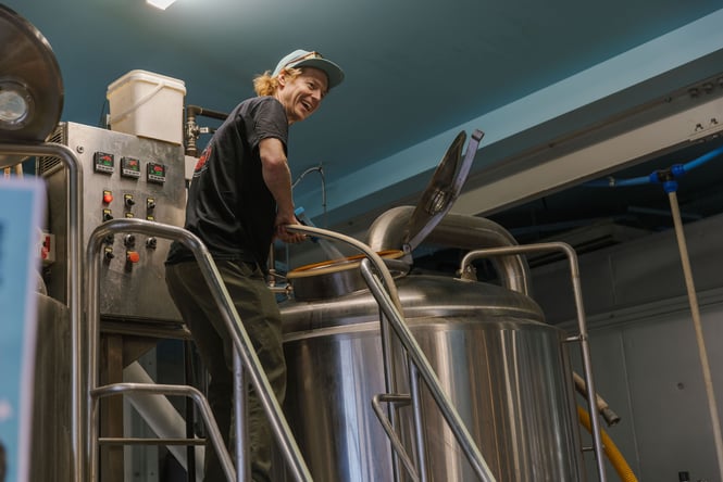 Cam brewing in the background of Southpaw Brewing Company in New Brighton