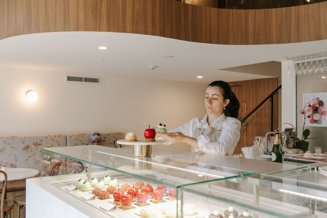 A staff member plating desserts.
