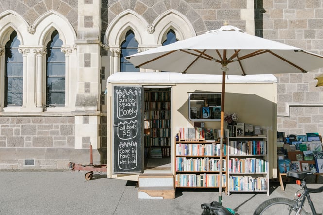 Exterior of Custard Square Bookshop with book display outside under an umbrella