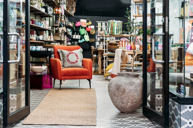 An orange chair inside the entrance to a retail store.