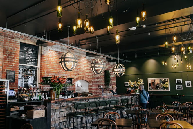 A staff member talking to a customer at the counter inside Cellar Door.