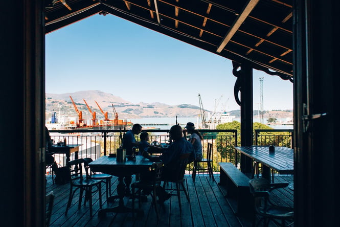 Customers sitting around tables outside Lyttelton Coffee Company.