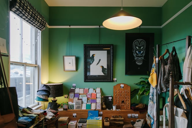 Gifts and homewares on display against a green wall inside Henry Trading.