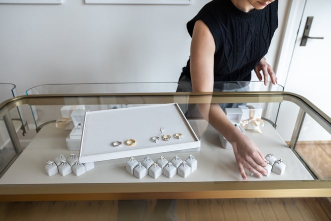 Shop assistant retrieving a jewellery item from the cabinet.