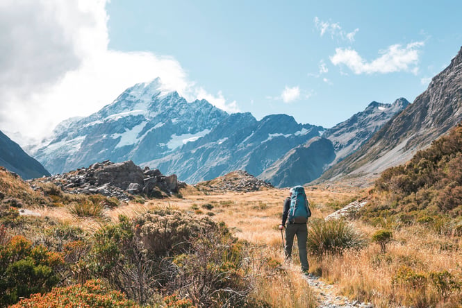 A person tramping on a mountain on a sunny day.