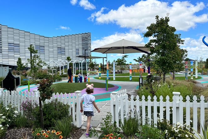 A child walking through a small white gate at the Rolleston Sensory Space.