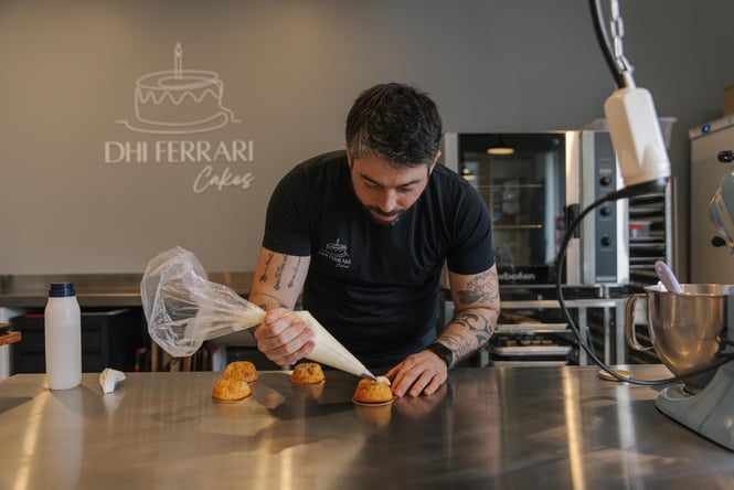 Baker piping filling into cakes.