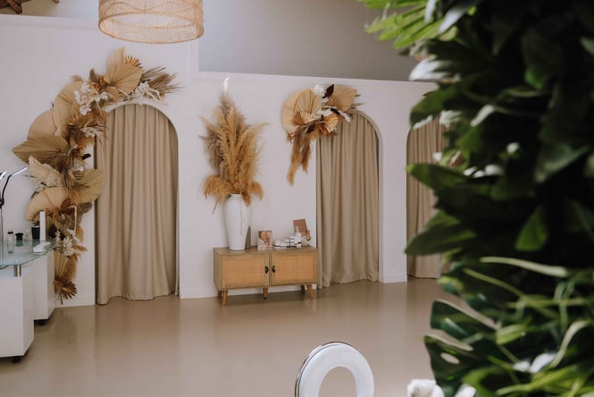 Curtains hanging over arched doorways inside Berry Beauty.