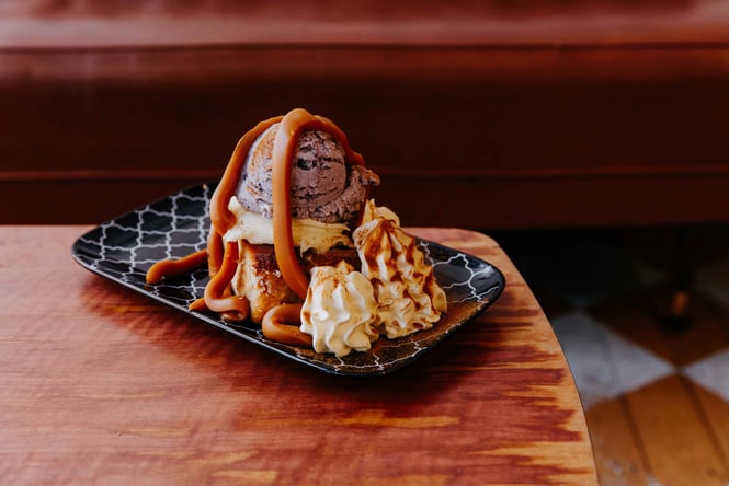 A massive plate of gelato, waffles and cream on a plate.