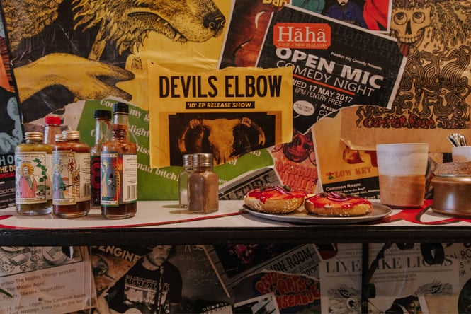 A bagel and sauces on a counter.