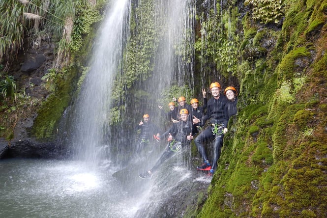People standing under a waterfall.
