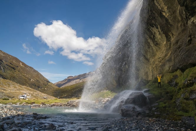 A person standing under a water fall.