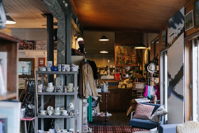 The retro interiors of the cafe with furniture and clothes on display.