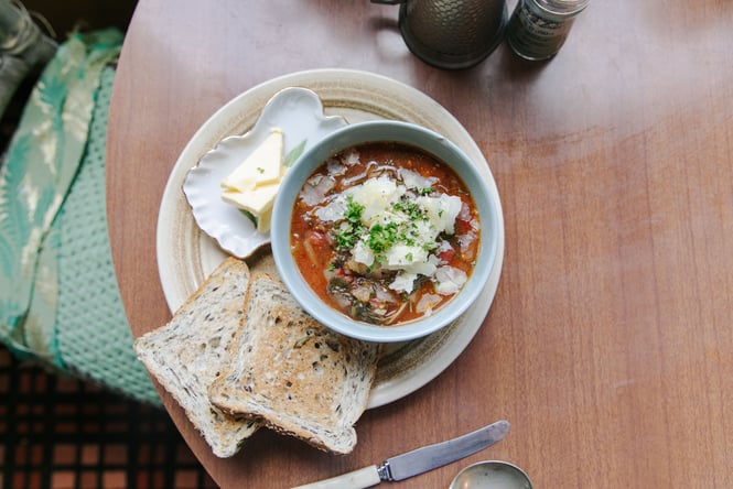 A flatly of tomato soup and toast on a table.