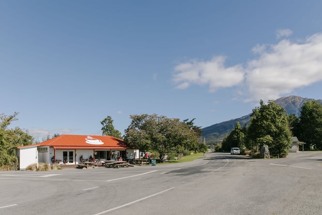 A white and orange building on a country road on a sunny day.