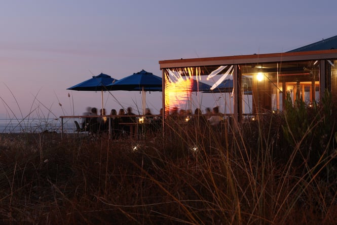 A cafe on a beach at dusk.