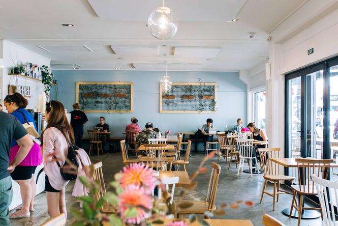 Customers dining inside a blue painted cafe.