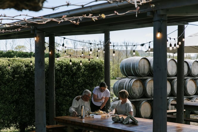 A staff member helping people at a table at Greystone wines.