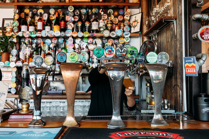 A person pouring a beer at a bar.
