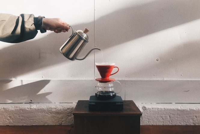 A hand pouring coffee at Pour and Twist.