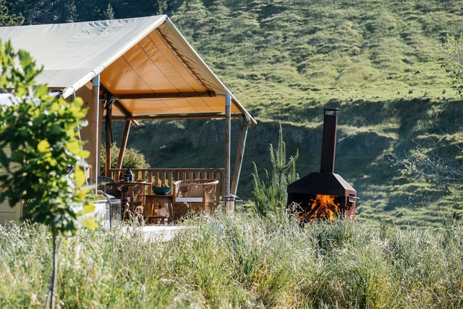 The glamping tent next to a fire place.