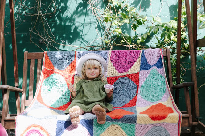 A little girl holding an ice cream in a cup.
