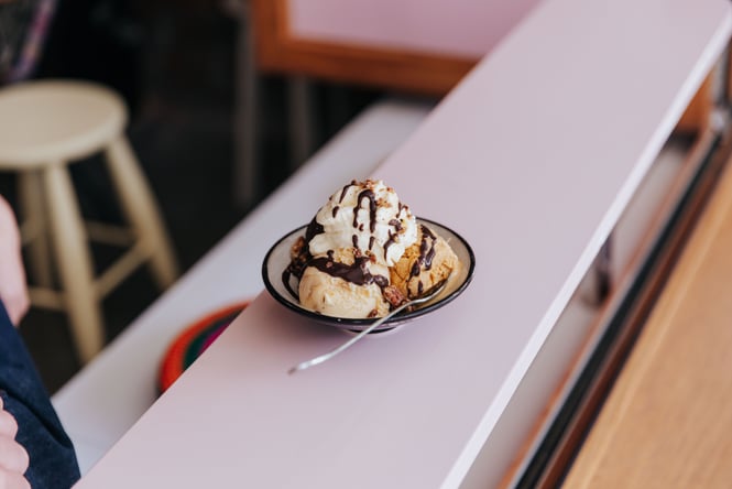 A bowl of ice cream on a pink counter.
