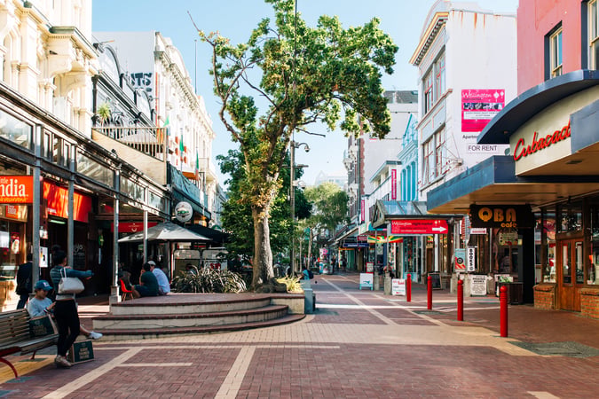 People sitting on tables on Cuba Street in Wellington.