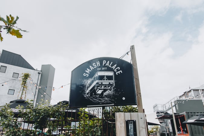A large black and white sign for Smash Palace on High Street.