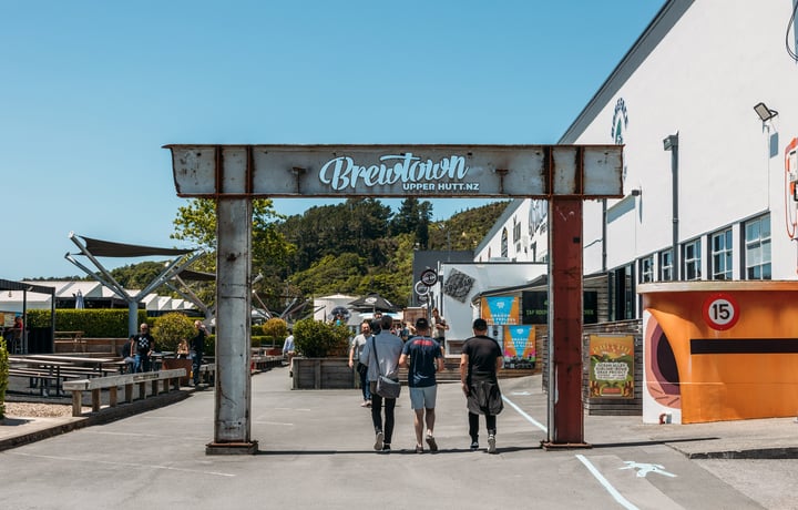 People walking under a large 'Brewtown' stign.