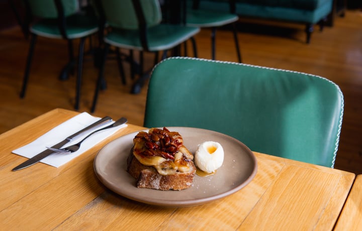 Elevated version of french toast with grilled bananas and a quenelle of cream on the side