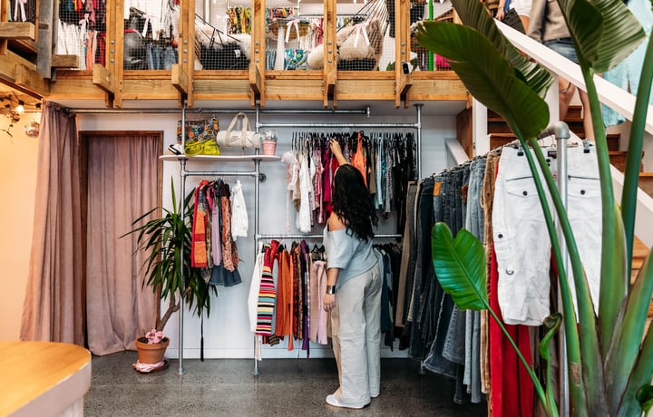 Customer browsing clothing racks in a vintage store.