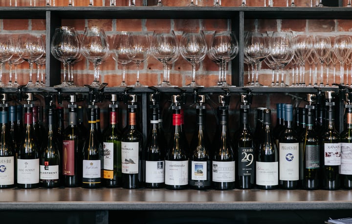 Bottles of red wine lined up in a row on a table.