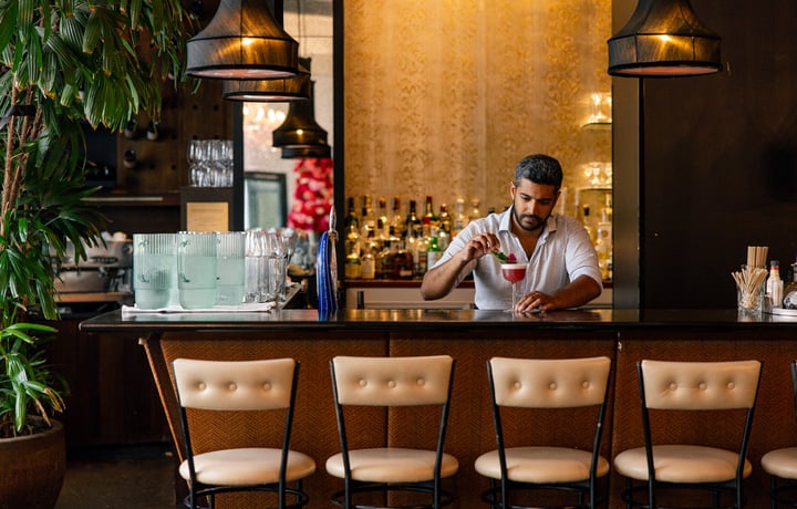 A man making a cocktail at a bar.