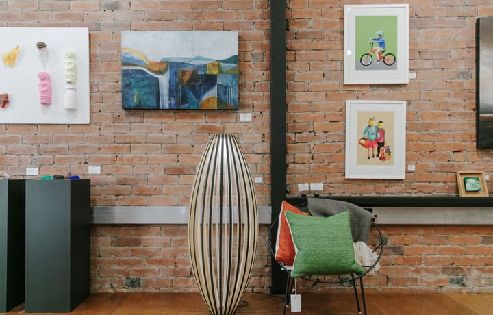 Interior view of art hanging on a brick wall at 77 Art + Living.