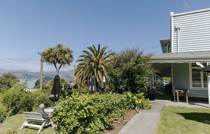 Lush garden area at Ōtoromiro Hotel in Governor's Bay overlooking water and hills