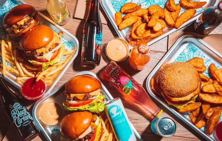 Birds eye view of silver trays filled with burgers and fries.