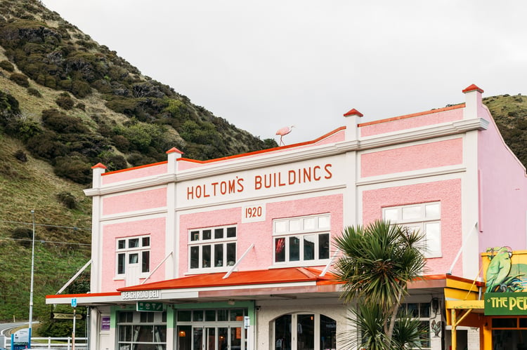 A retro pink and red building on a cloudy day.
